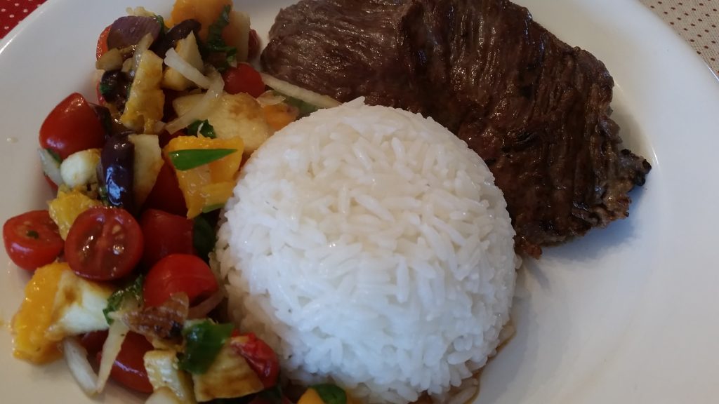 Prato de bife grelhado com arroz e salada colorida
