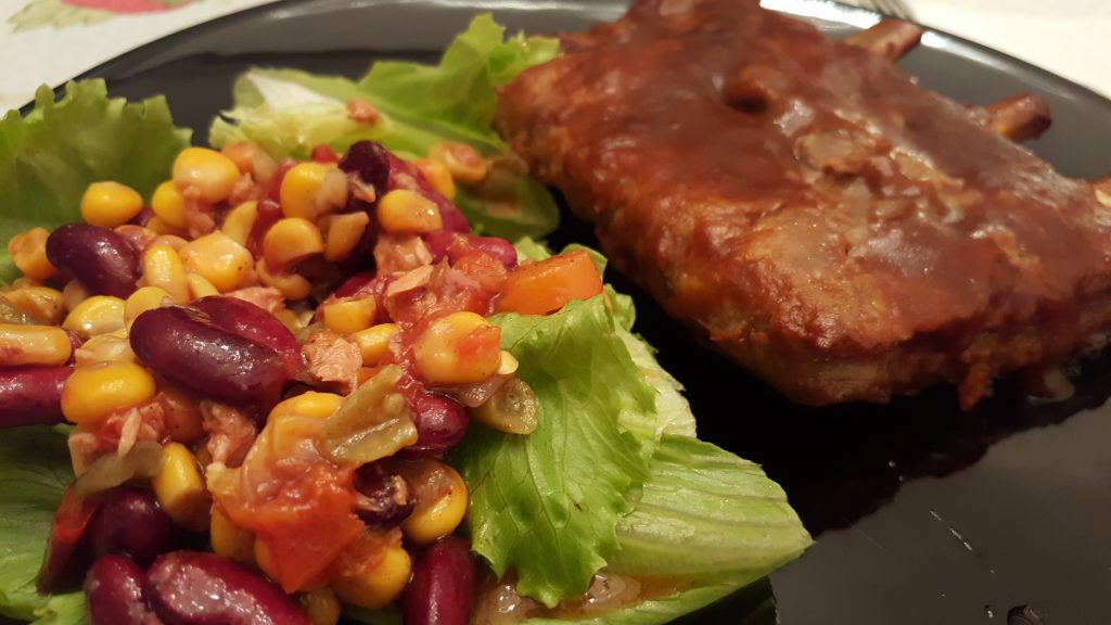Prato de costelinha com salada de feijão, milho e alface