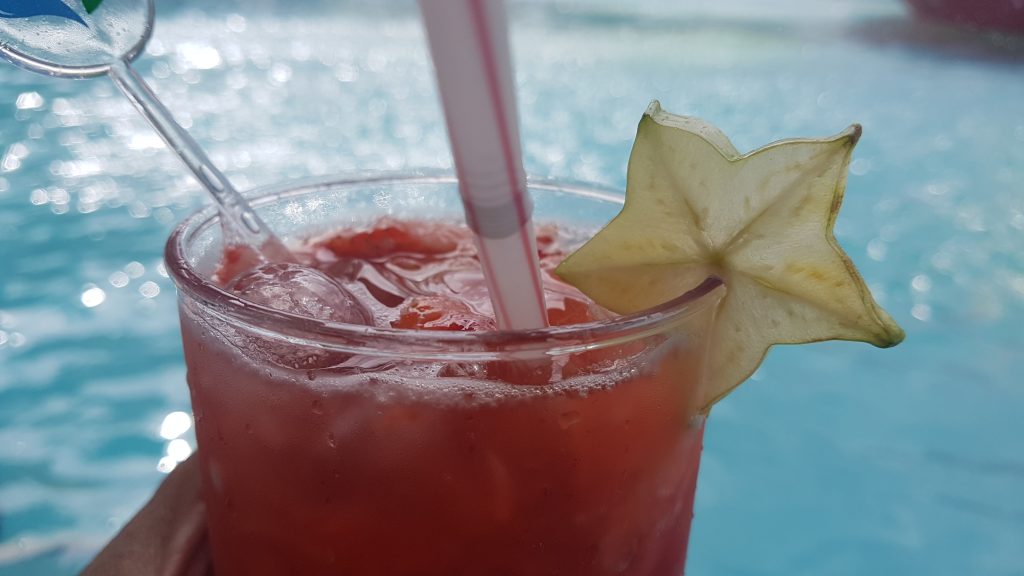 Drink tropical com carambola à beira da piscina