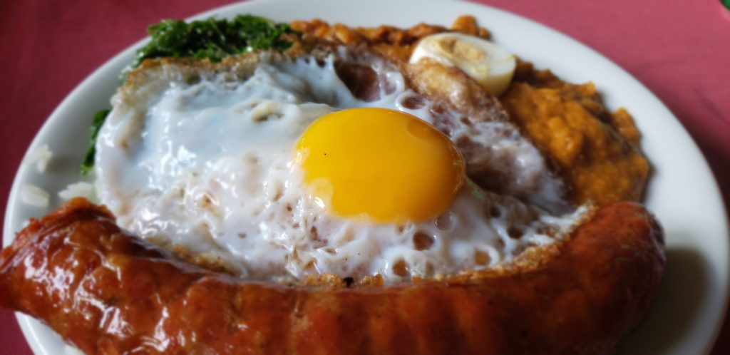 Prato de feijoada com ovo frito e linguiça