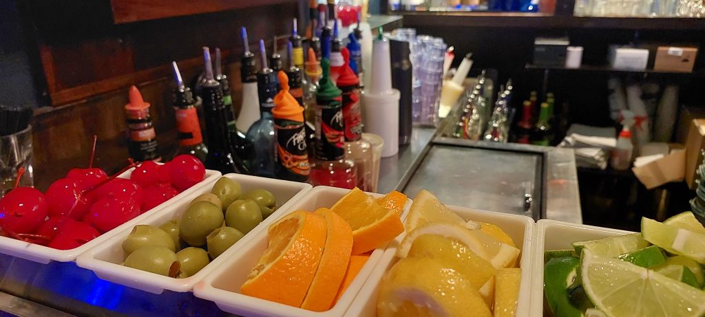 Balcão de bar com frutas e utensílios de coquetelaria